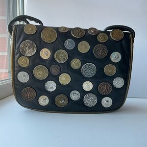 Foreign coin decorated black leather bag w pipping. Othello brand v